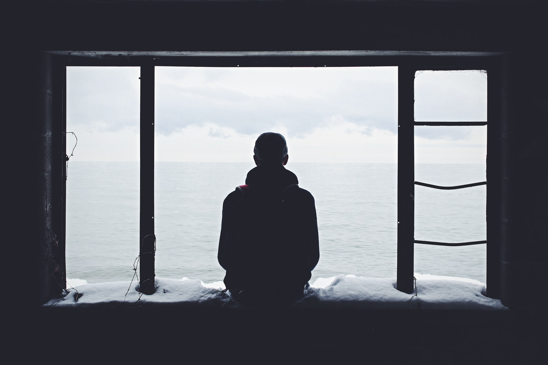 Silhouette of a person sitting at a window and looking out